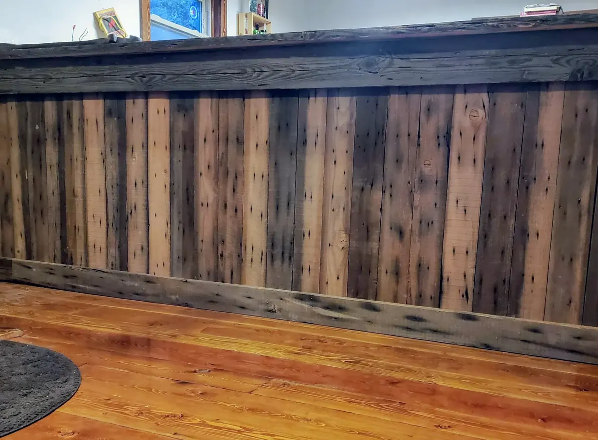 Bar front finished with varied reclaimed-wood planks