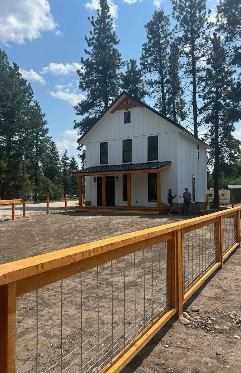 Wide exterior entry gate built with heavy timber and wire panels