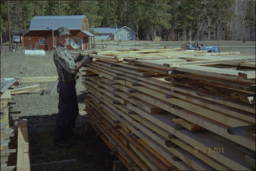 Mill worker stacking fresh-cut boards at Camas Creek in 2001